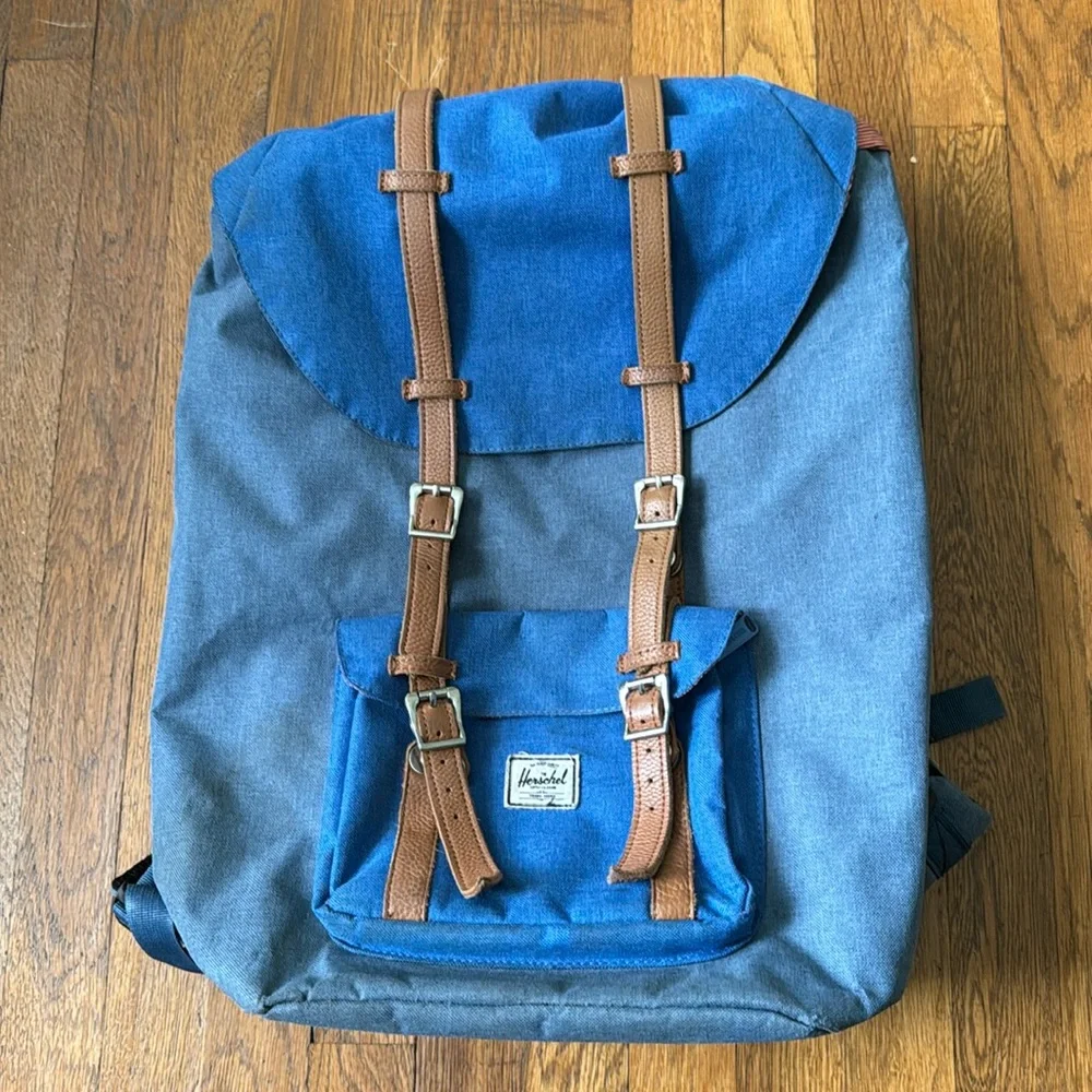 Herschel Retreat blue backpack with striped lining and brown leather trim.